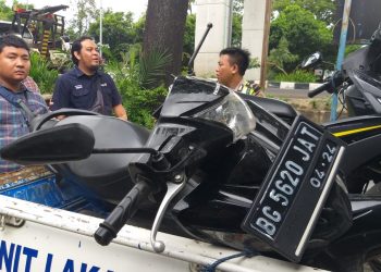 Petugas Unit Laka Satlantas Polresta Palembang mengevakuasi motor korban. (ist)