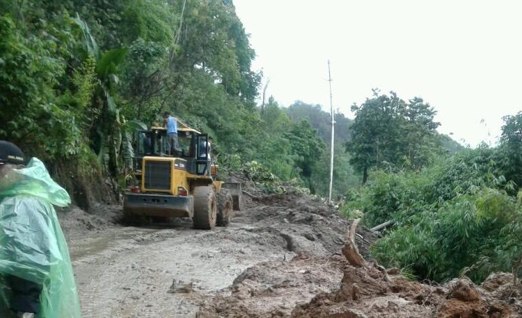 Alat berat sedang membersihkan material longsor yang menimbun jalan lintas Lahat-Pagaralam baru-baru ini. (ist)