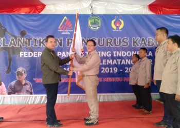 Ketua Umum Pengprov FPTI Sumsel Beni Hernedi menyerahkan bendera FPTI kepada Ketua FPTI PALI Ahmad Jhoni pada pelantikan kepengurusan FPTI PALI masa bakti 2019-2023 di halaman rumah dinas Bupati PALI, Kamis (30/01). (ist)