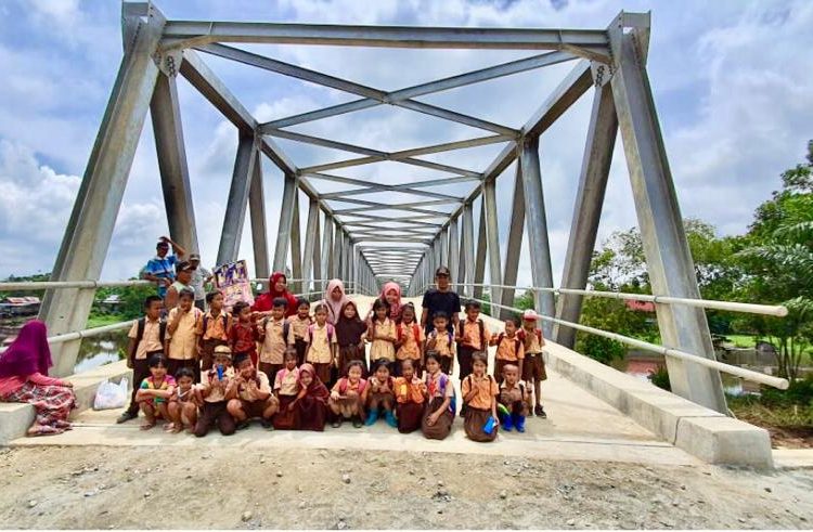 Warga dan siswa dari Desa Muara Medak berfoto di Jembatan Muara Medak I, Jumat (31/01), yang menunggu diresmikan. (ist)
