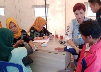 Petugas kesehatan saat memeriksa pasien yang merupakan pengunjung pasar Shopping Kayuagung, Sabtu (18/01). (Foto : fornews.co / Riyan Fahrizal)