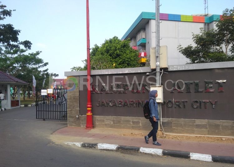 Seorang pengunjung melintas di depan papan nama Kampung Atlet Jakabaring Sport City beberapa waktu lalu. (fornews.co/iwan setiawan)