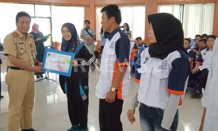 Fitriani saat menerima bonus secara simbolis dari Pemkab OKI di Kayuagung, Selasa (28/01). (Foto : fornews.co / rif)