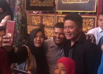Gubernur Sumsel Herman Deru melayani permintaan foto selfie pengunjung wisata religi Alquran Al Akbar di Kecamatan Gandus, Rabu (01/01). (ist)