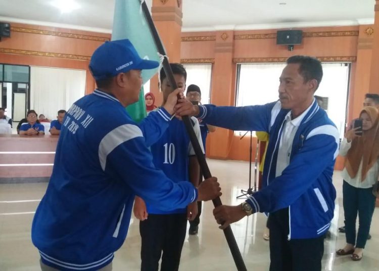 Wakil Bupati OKI, H M Dja'far Shodiq saat menyerahkan bendera petaka sebagai pertanda dimulainya perjuangan tim Singa OKI pada ajang Piala Soeratin U-15 tingka Nasional. (IST)