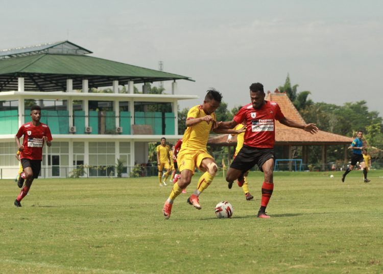 Penyerang Sriwijaya FC Rudiyana berjibaku dengan pemain Persipura Jayapura pada laga uji coba di lapangan Yogyakarta International School, Selasa (25/02). (media officer sriwijaya fc)