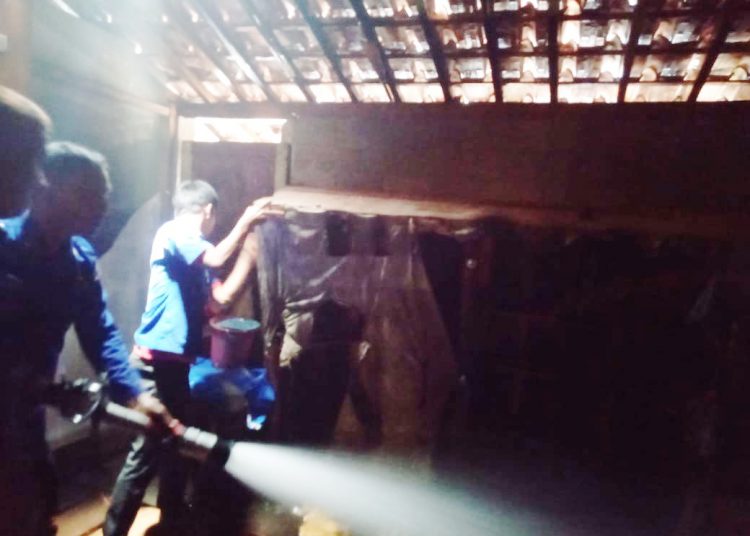 Petugas saat melakukan upaya pendinginan di rumah warga yang terbakar, Rabu (26/02). (IST)