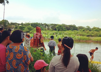 Warga di Jalan Pangeran Ratu berkerumun menyaksikan angkot yang nyemplung ke sungai, Sabtu (11/04) sore. (fornews.co/rusli gumay)