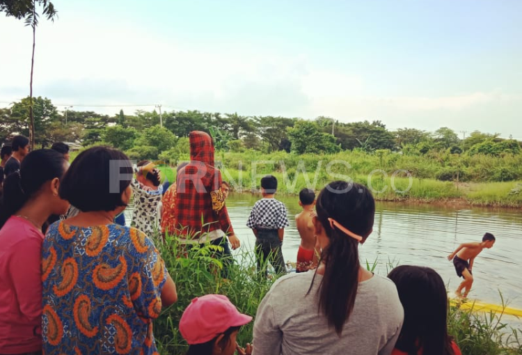 Warga di Jalan Pangeran Ratu berkerumun menyaksikan angkot yang nyemplung ke sungai, Sabtu (11/04) sore. (fornews.co/rusli gumay)