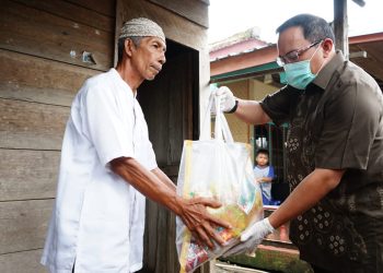Bupati Muba Dodi Reza Alex saat menyerahkan bantuan paket sembako dari IKAPTK Muba kepada warga yang terdampak wabah Covid-19 di Kelurahan Balai Agung, Kecamatan Sekayu, Jumat (03/04). (humas pemkab muba)