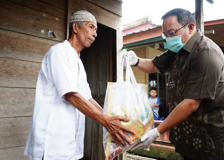 Bupati Muba Dodi Reza Alex saat menyerahkan bantuan paket sembako dari IKAPTK Muba kepada warga yang terdampak wabah Covid-19 di Kelurahan Balai Agung, Kecamatan Sekayu, Jumat (03/04). (humas pemkab muba)