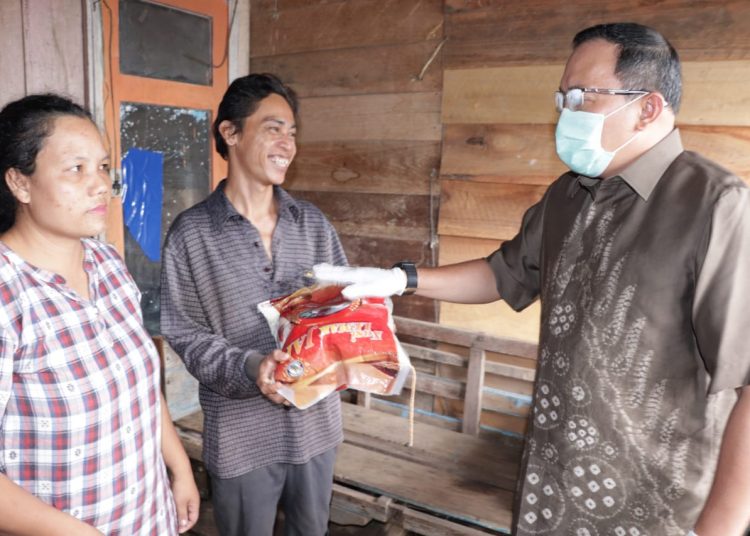 Bupati Muba Dodi Reza Alex saat menyerahkan bantuan paket bahan pokok kepada warga Muba yang terdampak COVID-19. (humas pemkab muba)