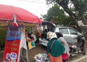 Beberapa warga hendak membeli masker kain di salah satu pedagang di Jalan Jenderal Ahmad Yani Palembang, Sabtu (11/04). (fornews.co/rusli gumay)