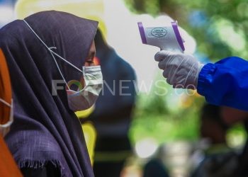 Seorang warga pendatang diperiksa petugas medis mengenakan APD lengkap setibanya di Terminal Alang Alang Lebar, Kota Palembang, Senin (20/04/2020). (matakamera/fornews.co/mushaful imam)