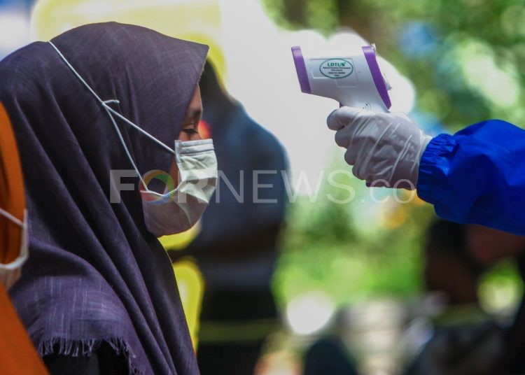 Seorang warga pendatang diperiksa petugas medis mengenakan APD lengkap setibanya di Terminal Alang Alang Lebar, Kota Palembang, Senin (20/04/2020). (matakamera/fornews.co/mushaful imam)