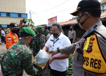 Bupati Muba Dodi Reza Alex dan Kapolres Muba AKBP Yudhi Surya Markus Pinem menyerahkan bantuan paket sembako kepada anggota TNI yang menjalankan tugas pengamanan siaga COVID-19 di wilayah Muba pada kegiatan Bakti Sosial Polda Sumsel Peduli COVID-19 di halaman Mapolres Muba, Selasa (21/04). (fornews.co/humas pemkab muba)