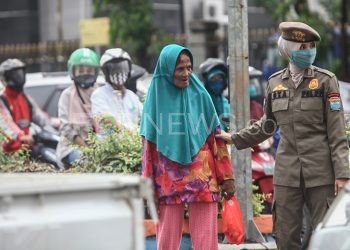 Seorang nenek diamankan petugas karena kedapatan tidak memakai masker saat beraktivitas di luar rumah. (matakamera/fornews.co/mushaful imam)