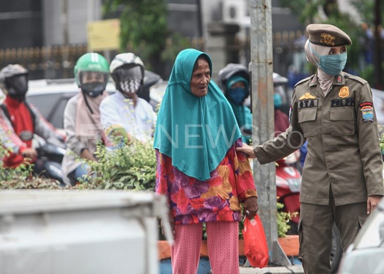 Seorang nenek diamankan petugas karena kedapatan tidak memakai masker saat beraktivitas di luar rumah. (matakamera/fornews.co/mushaful imam)
