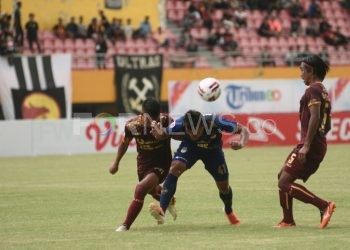 Dua pemain Sriwijaya FC Erwin Gutawa dan Agi Pratama mencoba menghadang laju penyerang PSIM Yogyakarta Slamet Budiyono pada laga pekan 1 Liga 2 2020 di Stadion Gelora Sriwijaya, Palembang, Minggu (15/03). Dikarenakan kompetisi dalam status force majeure, seluruh pemain akan terkena potongan gaji selama kompetisi dihentikan. (dok/fornews.co/mushaful imam)