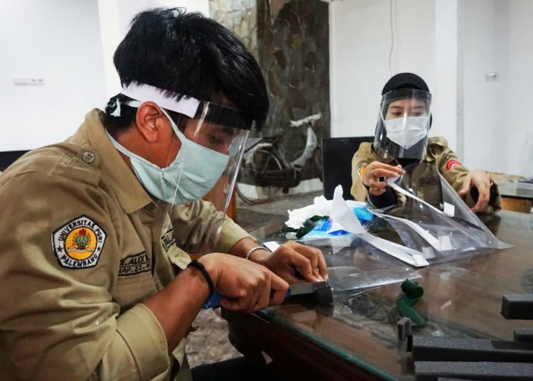 Anggota Mapala Palaspa Universitas PGRI Palembang saat memproduksi APD handmade face shield, Sabtu (4/4). (fornews.co/ist)