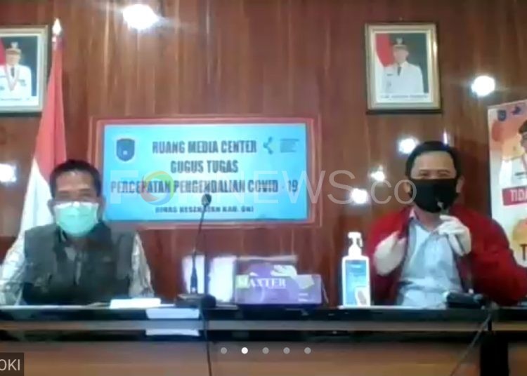 Jubir Gugus Tugas COVID-19 Kabupaten OKI, Iwan Setiawan (kiri) bersama Kepala Dinas Kominfo OKI, Alexander saat telekonferensibersama wartawan, Selasa (28/04) malam. (Fornews.co / rif)