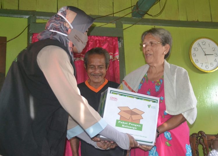 Relawan Dompet Dhuafa Sumsel menyerahkan bantuan paket pangan kepada warga dhuafa yang terdampak COVID-19, Selasa (21/04). (fornews.co/ dompet dhuafa sumsel)