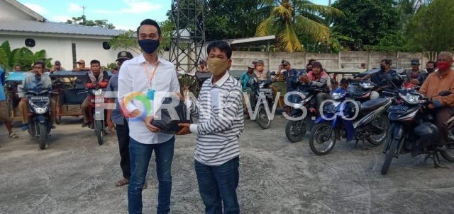 Muchendi Mahzarekki, Anggota DPRD Sumsel saat menyerahkan bantuan sembako kepada salah seorang tukang ojek di Kayuagung, Kabupaten OKI, Sumsel, Senin (20/04). (foto : fornews.co / rif)