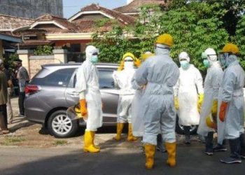 Petugas medis dan pemakaman mengenakan APD lengkap bersiap membawa jenazah PDP-26 untuk dimakamkan, Jumat (24/04). (fornews.co/ist)