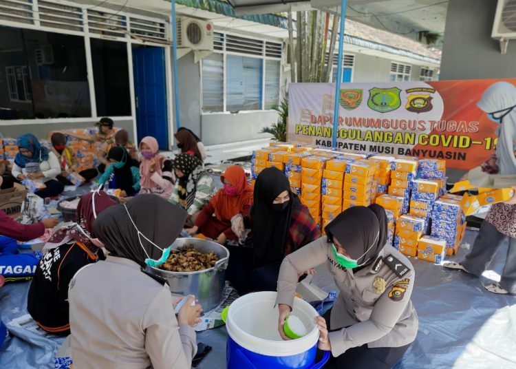 Anggota Polwan dan ibu-ibu Bhayangkari Polres Muba serta ASN Pemkab Muba mengemas makanan di dapur umum yang akan dibagikan ke masyarakat terdampak COVID-19, Minggu (10/05). (fornews.co/humas pemkab muba)