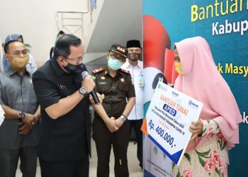 Bupati Muba Dodi Reza Alex saat menyerahkan secara simbolis Bantuan Sosial Tunai APBD Kabupaten Muba Tahun 2020 untuk Masyarakat Terdampak COVID-19 di Kantor Cabang BRI Sekayu, Senin (11/05). (fornews.co/humas pemkab muba)