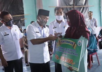 Sekda Muba Apriyadi saat menyerahkan BLT di Desa Ulak Paceh, Kecamatan Lawang Wetan, Selasa (12/05). (fornews.co/humas pemkab muba)