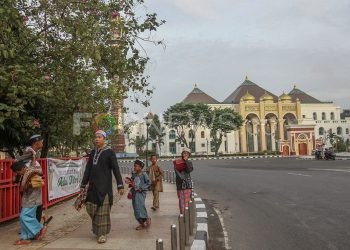 Tampak bapak dan anak harus kembali ke rumah karena Masjid Sultan Mahmud Badaruddin Jayo Wikramo tidak menggelar salat Id 1441H tahun lalu. Tahun ini Pemkot Palembang kembali memutuskan peniadaan salat Idulfitri. 1442H. (matakamera/fornews.co/mushaful imam)