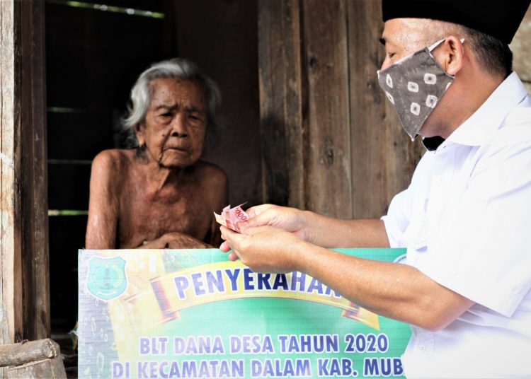 Sekda Muba Apriyadi menyerahkan BLT DD kepada Zumiah seorang nenek berusia 100 tahun lebih warga Desa Talang Piase, Kecamatan Lawang Wetan, Kamis (28/05). (fornews.co/humas pemkab muba)