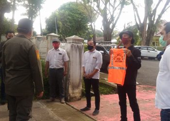 Relawan COVID-19 di Palembang saat menyerahkan secara simbolis kepada gugus tugas rompu oren sebagai hadiah untuk Wali Kota Palembang yang diduga melakukan pelanggaran PSBB. Foto: Istimewa