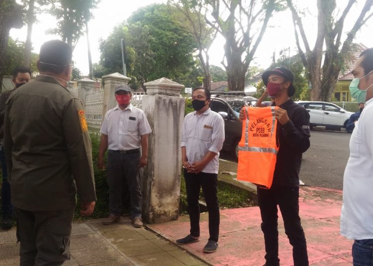 Relawan COVID-19 di Palembang saat menyerahkan secara simbolis kepada gugus tugas rompu oren sebagai hadiah untuk Wali Kota Palembang yang diduga melakukan pelanggaran PSBB. Foto: Istimewa