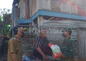 Danramil 402-06/Tanjung Batu, Kabupaten Ogan Ilir saat menyerahkan beras pada bakti sosial di Desa Sentul, Kecamatan Tanjung Batu, Kabupaten Ogan Ilir, Senin (11/05). (Foto : fornews.co / rif)