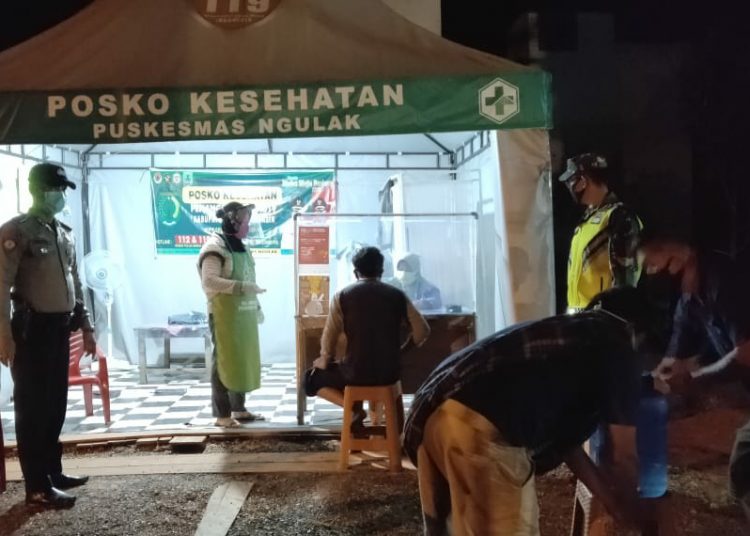 Petugas kesehatan dari Puskesmas Ngulak, Kecamatan Sanga Desa, Kabupaten Muba, memeriksa kesehatan pengendara yang melintas Posko perbatasan Muba. (fornews.co/ist)