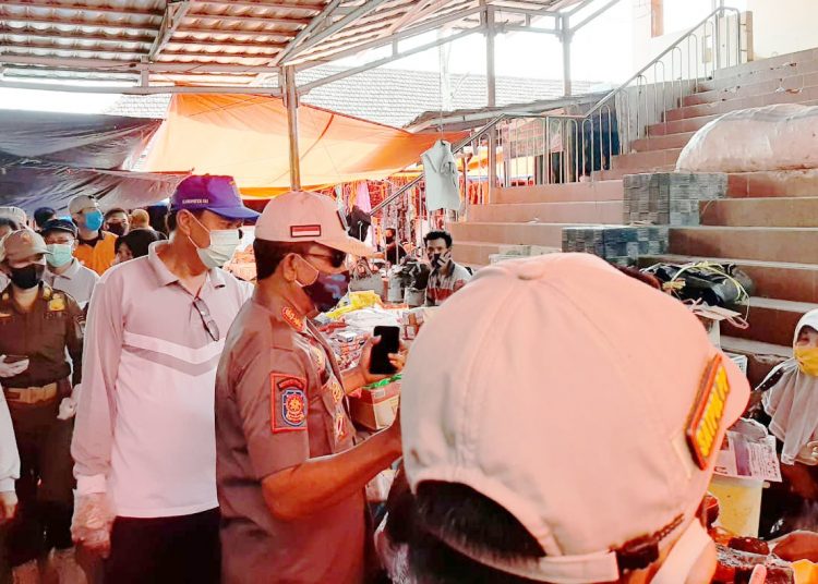 Kepala Dinas Perdagangan Kabupaten OKI, Sudiyanto Djakfar bersama Sat Pol PP OKI saat memberikan imbauan kepada pedagang dan pengunjung di pasar untuk tetap mematuhi protokol kesehatan guna mencegah penularan virus Corona. (IST)