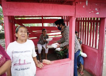 Wakil Ketua PWPM Sumsel, Ruspanda Karibullah, saat membagikan nasi kotak di Lorong Abadi, Kelurahan Sei Selincah, Kecamatan Kalidoni, Palembang, Jumat (15/5). (fornews.co/ist)
