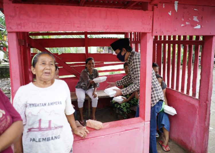 Wakil Ketua PWPM Sumsel, Ruspanda Karibullah, saat membagikan nasi kotak di Lorong Abadi, Kelurahan Sei Selincah, Kecamatan Kalidoni, Palembang, Jumat (15/5). (fornews.co/ist)
