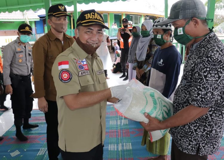 Sekda Muba Apriyadi menyerahkan bantuan Pemkab Muba kepada warga Trans SP I dan SP II Desa Air Balui, Kecamatan Sanga Desa, Senin (01/06). (fornews.co/humas pemkab muba)