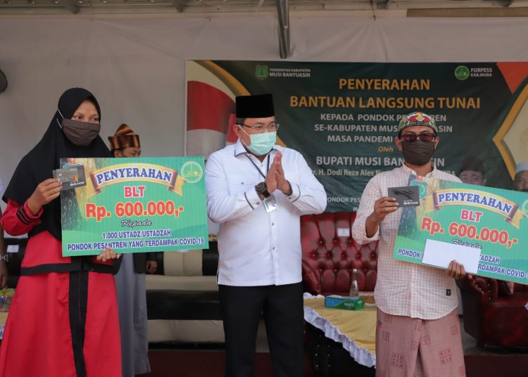 Bupati Muba Dodi Reza Alex saat menyerahkan bantuan sosial tunai kepada ustaz dan ustazah secara simbolis di Pondok Pesantren Riyadhul Aliyyah Desa Mekar Jadi, Kecamatan Sungai Lilin, Rabu (03/06). (fornews.co/humas pemkab muba)