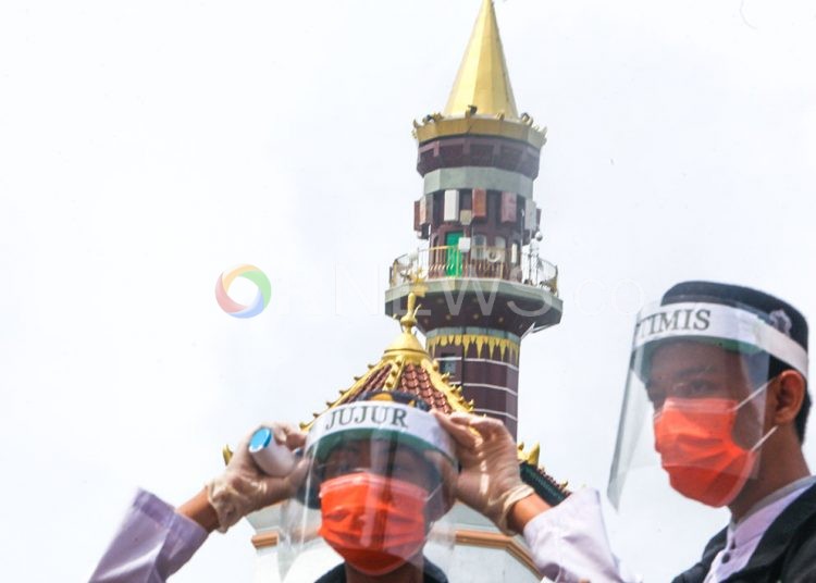 Pengurus Masjid SMB Jayo Wikramo menggunakan pelindung wajah dan masker serta dilengkapi thermo gun siap memeriksa jemaah yang akan melaksanakan salat Jumat. (matakamera/fornews.co/mushaful imam)