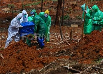 Petugas TPU Gandus menggotong peti jenazah pasien Covid-19 yang akan dimakamkan, Kamis (5/6/2020). (matakamera/fornews.co/mushaful imam)