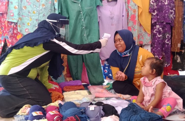 Seorang pedagang di Pasar Randik, Sekayu, diperiksa suhu tubuhnya oleh petugas dari Dinas Kesehatan Muba sebagai bagian dari sosialisasi dan edukasi mengenai tatanan kehidupan Normal Baru, Sabtu (06/06). (fornews.co/humas pemkab muba)
