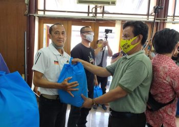 Kabid Humas dan Publikasi KONI Sumsel Rustam Imron menyerahkan paket bantuan kepada pelatih atletik Kadir Sani, Sabtu (13/06). (fornews.co/humas koni sumsel)