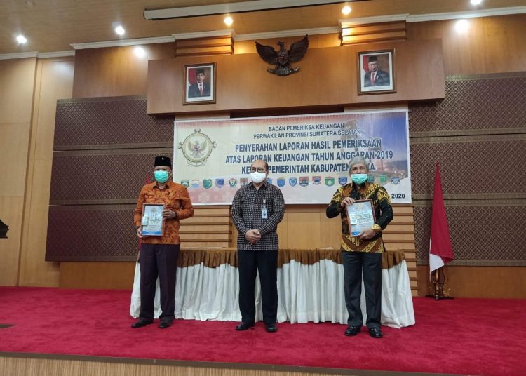 Bupati OKI, H Iskandar SE (kanan) saat menerima secara simbolis penghargaan dari BPK RI di Palembang, Rabu (17/06). (IST)