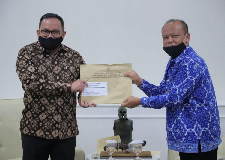 Kepala BKN Regional VII Palembang Agus Sutadi menyerahkan dokumen kepegawaian kepada Bupati Muba Dodi Reza Alex pada kunjungan kerja ke Kabupaten Muba, Jumat (19/06). (fornews.co/humas pemkab muba)