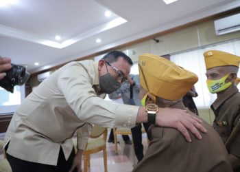 Bupati Muba Dodi Reza Alex menyapa salah seorang veteran di Muba usai menyerahkab bantuan, Selasa (23/06). (fornews.co/humas pemkab muba)