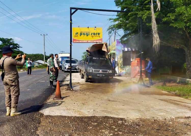 Mobil yang melintas di Posko Pengawasan COVID-19 di Dusun I, Desa Sukamaju, Kecamatan Babat Supat, dilakukan penyemprotan disinfektan dan penumpangnya diperiksa kesehatannya sebelum masuk wilayah Muba, Kamis (25/06). (fornews.co/humas pemkab muba)